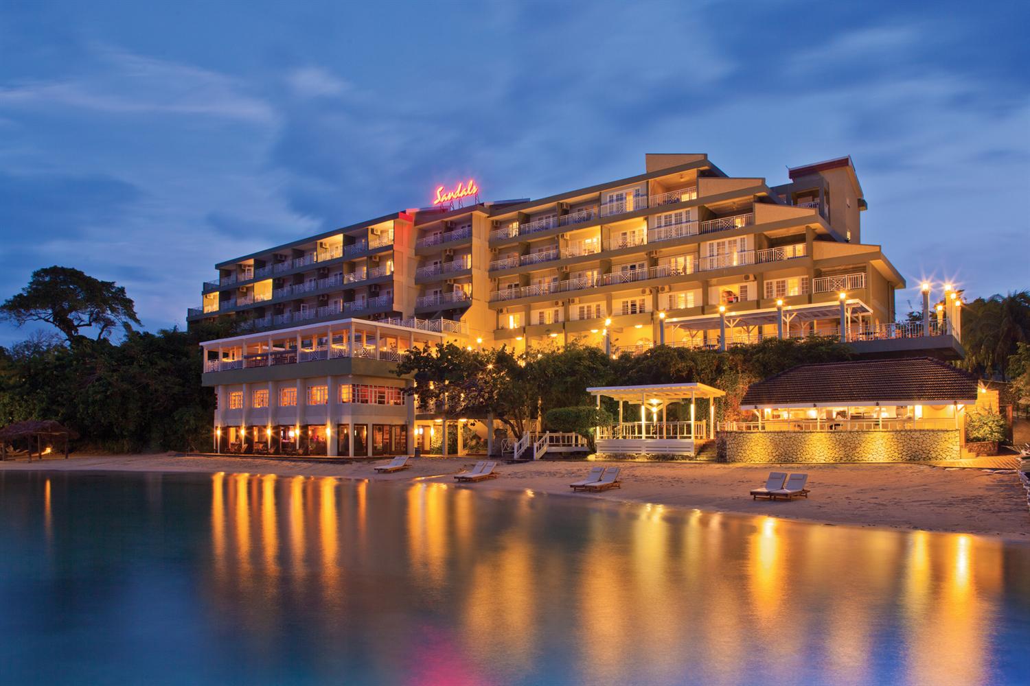 The Great Pool becomes a romantic setting at night. | Sandals ochi beach resort, Beaches resort 